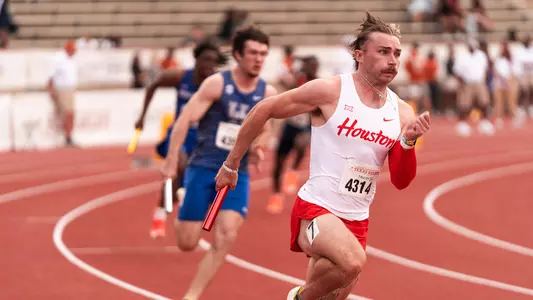 Ryan Mulholland running with baton at Texas Relays