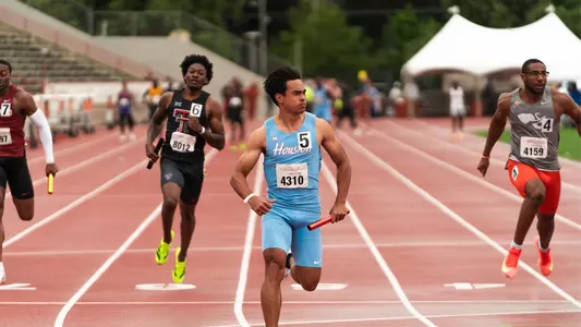Louie Hinchliffe crossing the finish line with baton in hand