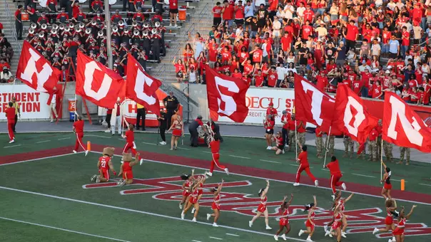 Cheerleaders run with flags that spell HOUSTON