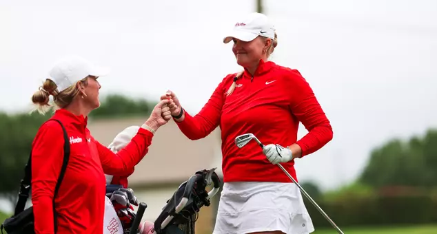 Carolyn Macow Leatherwood Head Lydia Lasprilla and Emilia Väistö bump fists following Väistö's drive.