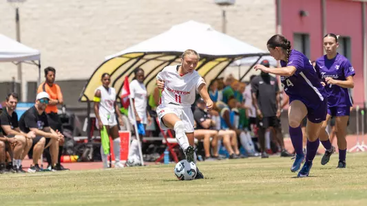 Skylar Miller dribbles soccer ball past defender