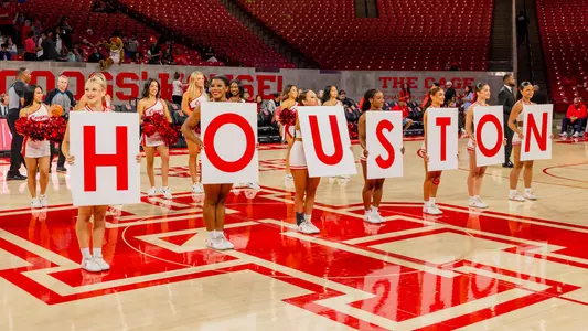 Cheerleaders holding signs that spell out Houston