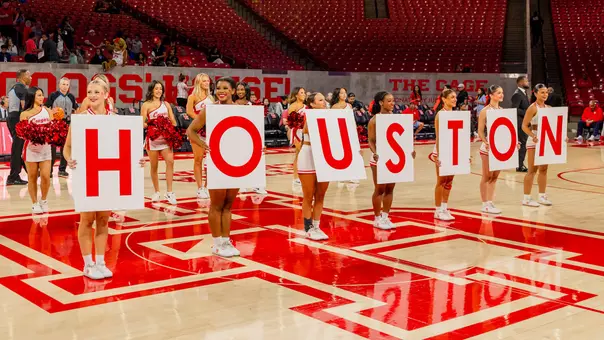 Cheerleaders holding signs that spell out Houston
