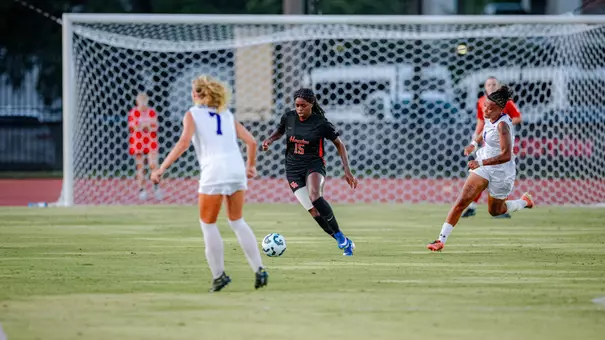 amaris bumba dribbles a soccer ball with defenders around her