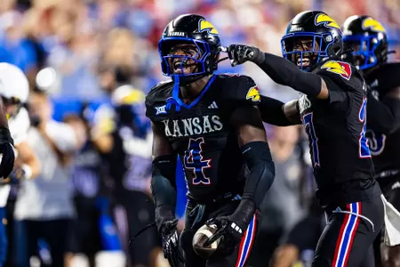 linebacker Trey Lathan #4 of the Kansas Jayhawks and safety Taylor Davis #27 of the Kansas Jayhawks