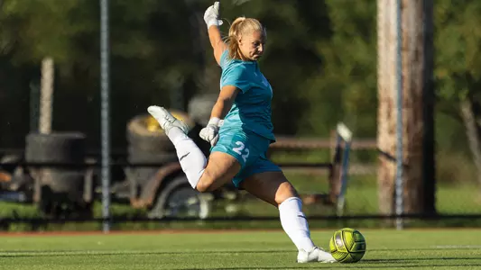 Kira Kutzinski kicks the ball up the field.