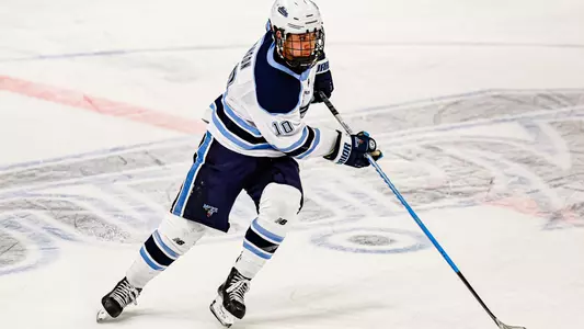 Cole Hanson with the puck in the neutral zone.