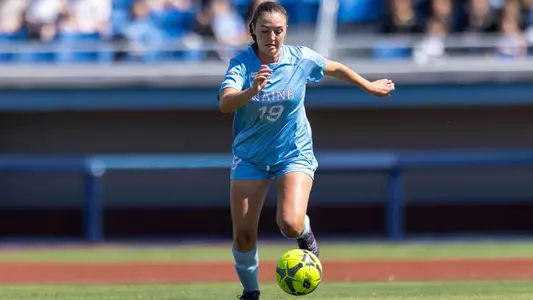 Amanda Clauzel dribbles the ball up the field.