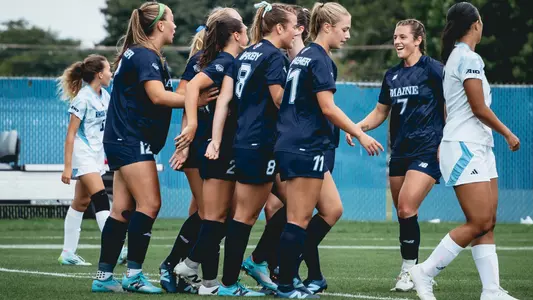 Women's soccer celebrates a goal.