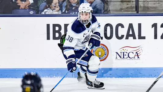 Oskar Komarov skates with the puck.