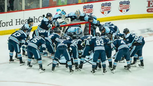 Maine men's hockey huddles before a game.