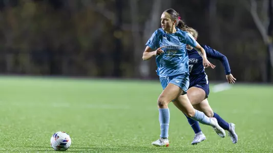 Julie Lossius dribbles the ball up the field.