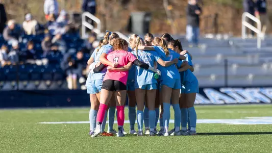 Maine women's soccer huddles before a game.