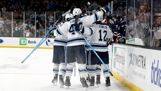 Maine men's hockey celebrates a goal.
