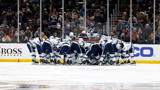 Maine men's hockey huddles around the net pregame.