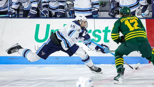 Taylor Makar dumps the puck into the offensive zone.