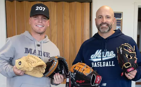 Head Coach Nick Derba and former maine baseball player Connor Goodman posing with baseball gloves.