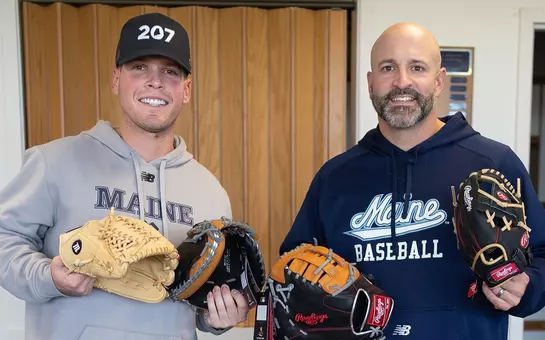 Head Coach Nick Derba and former maine baseball player Connor Goodman posing with baseball gloves.
