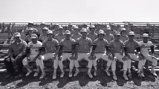 A team photo of the 1976 Maine Baseball sitting on the bleachers.