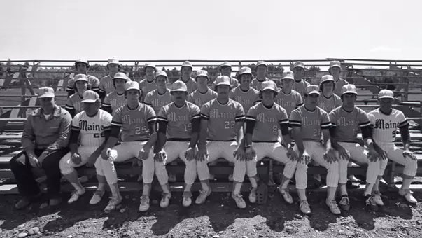 A team photo of the 1976 Maine Baseball sitting on the bleachers.