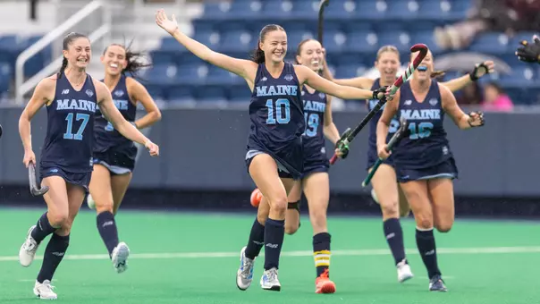 Field hockey celebrates a goal.
