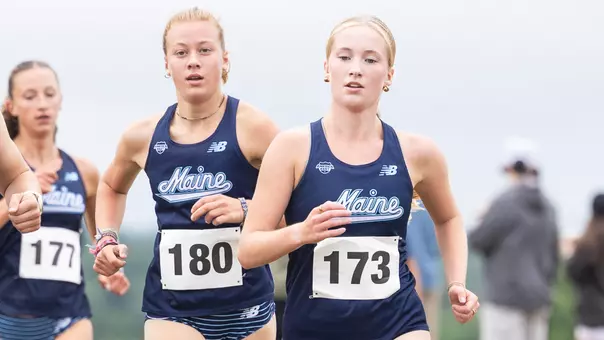 Two runners, wearing navy, run against Army
