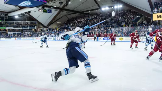 Wide shot of Alfond ARena from the corner a Max Scott takes a slap shot.