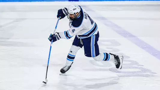 Brandon Holt shoots the puck into the offensive zone.