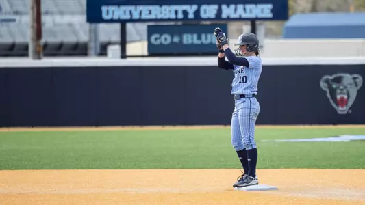 Keira Inman stands on second base, clapping.
