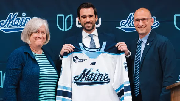 Alex Gettens is presented a jersey from President Ferrini-Mundy and Jude Killy.