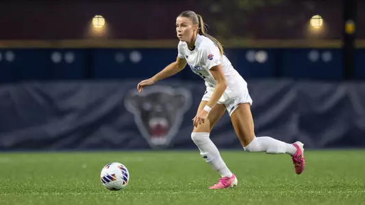Hilary Washington dribbles the ball up the field.