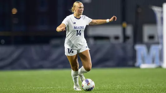 Britta Denny dribbles the ball up the field.