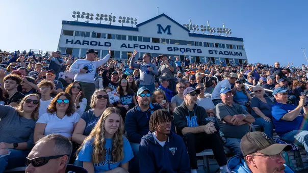Two people do a high-five at Alfond Stadium