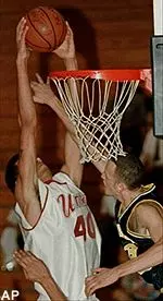 Jesus Rodriguez from the American University tries to defend against a two-handed dunk by Micah Brand from the University of Massachusetts during the Puerto Rico Holiday Classic.