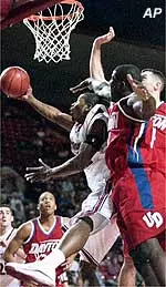 Chris Kirkland shoots a reverse layup under heavy pressure from two Dayton defenders.
