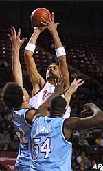 Micah Brand shoots over URI's Marcus Evans and Andre Scott in the first half Tuesday night at home.