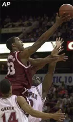 Massachusetts' Kitwana Rhymer, center, shoots over Temple's Ron Rollerson, right, and Lynn Greer, left, during the first half of the championship game at the Atlantic 10 tournament Saturday.
