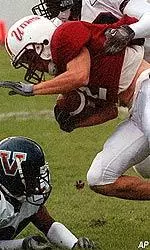 Wide receiver Adrian Zullo tries to get away from Villanova linebacker Darnell Greene in the first half.