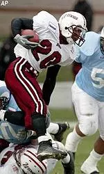 Raunny Rosario leaps over a fallen teammate while being chased by a Rhode Island defender in first half action.