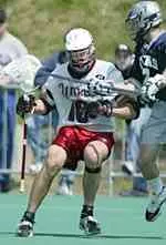 Neil Lundberg holds off a Georgetown defender. The Minutemen battle Syracuse on Saturday, April 26 at 1:00 p.m.