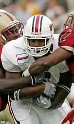 Steve Baylark is wrapped up by Boston College's Larry Anam and Tyronne Pruitt during the third quarter.