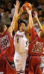 Rashaun Freeman looks to kick the ball out of the post after grabbing a rebound over two Hawk defenders.