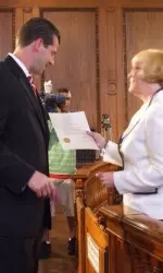 Derek Kellogg receiving his proclamation from Kateri Walsh.