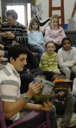 Michael Marcou reads to a third-grade class in the library.