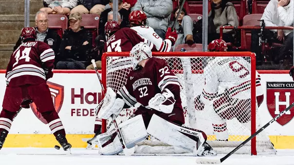 Ethan Eskit in net as team battles for puck behind the goal at Harvard