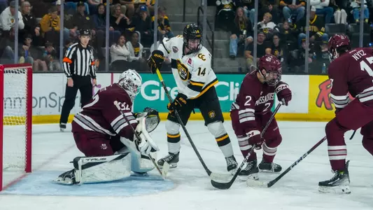 Puck battle in front of Ethan Eskit at Colorado College