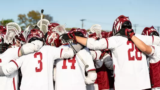 Men's Lacrosse team huddle showing players helmets and backs