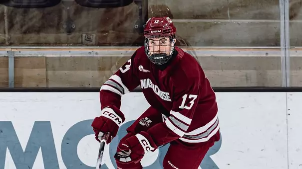 Landon Nycz skates with the puck in maroon at Army