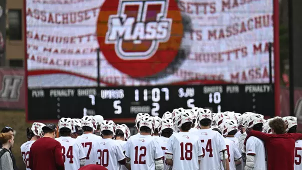 Men's Lacrosse In-Game Huddle with scoreboard in background