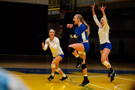Maddie Renn, Alex Ratzlaff and Melanie Brecka Celebrate after an ace against NM State
